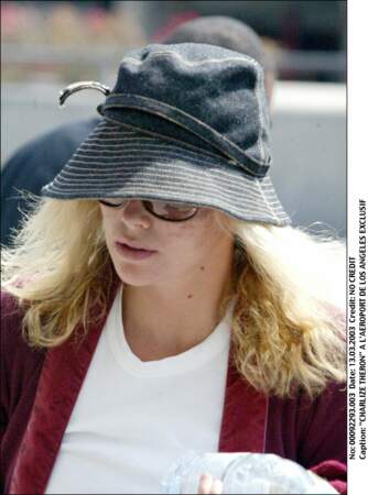 2003 : Charlize Theron à l’aéroport est aussi naturelle que possible. Cheveux en bataille et chapeau de feutre sont de rigueur. 