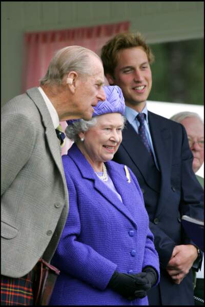 2005 : La Reine Elizabeth II, le prince Philip et le prince William s'amusent lors d'un "Braemar Royal Highland Gathering".