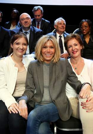 Brigitte Macron accompagnée d' Aurore Bergé et Frédérique Dumas à La Plaine-Saint-Denis. Elle un petit col montant gris claire superposé avec une veste grise. 
Mme.Macron porte régulièrement des camaïeu de gris. 