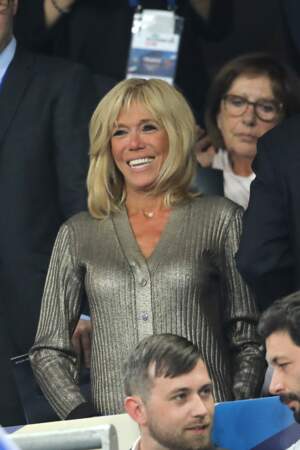 9 septembre 2018 : La Première Dame Brigitte Macron au Stade de France portait un petit gilet gris métallisé et brillant. 