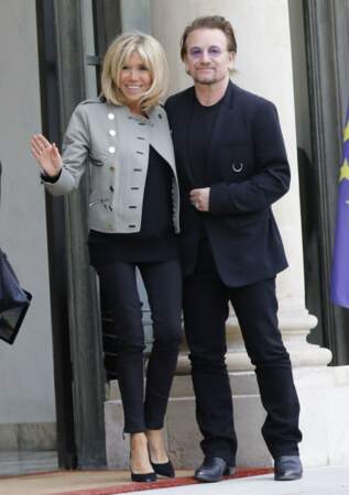 Brigitte Macron à l'Elysée le 24 juillet 2017. Raccompagnant le musicien Bono jusqu'à la sortie, elle porte un blouson gris dans un style rock. 