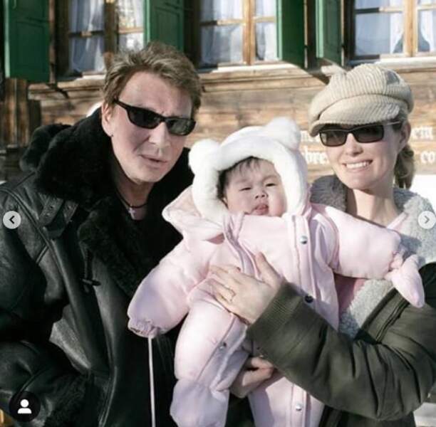 Jade Hallyday lorsqu'elle était bébé, accompagnée de ses parents, Johnny et Laeticia Hallyday. 
Jade n'a pas encore 1 an sur la photo. Jade Hallyday est née le 3 août 2004 au Vietnam et a été adoptée en novembre 2004 par le couple Hallyday.