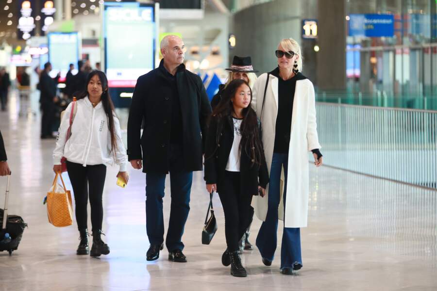 Jade Hallyday, accro aux marques de luxe, comme son sac Goyard. Ici avec sa famille à l'aéroport Roissy CDG le 19 novembre 2019. 