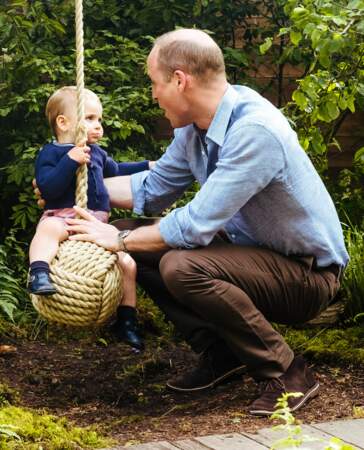 Le prince Louis s'essayant à la balançoire - élément de décor voulu par Kate Middleton - sous le regard de son père William.