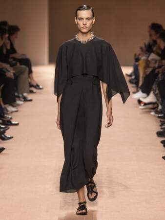 Hermès propose une robe noire aux épaules larges, version châle. 