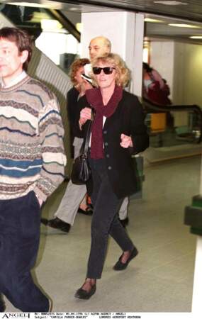 Avril 1996 : Camilla Parker Bowles est habillée "décontracté" pour se rendre à l'aéroport Heathrow. Jean, gilet, chaussures plates et lunette de star, Camilla porte un look au goût du jour.