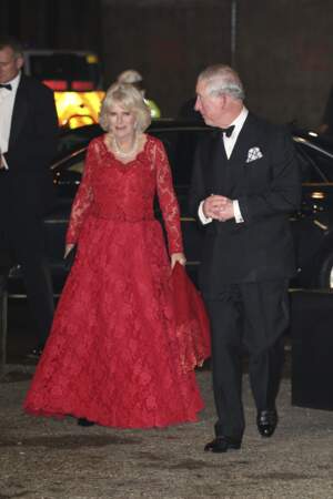 6 décembre 2016 : Lors du Royal Variety Performance, Camilla Parker Bowles, accompagnée de son époux, le prince Charles, ose le rouge avec une robe longue en dentelle. Elle porte tout de même le traditionnel collier de perles.