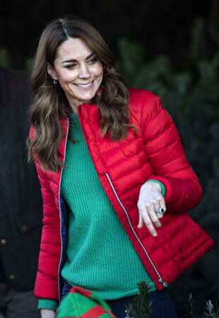 Kate Middleton a pris de l'assurance, elle s'amuse à mixer les couleurs comme ce pull vert sous une doudoune rouge, esprit de noel 2019 moderne.