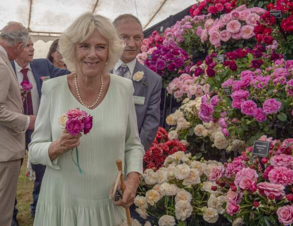 24 juillet 2019 : La duchesse de Cornouailles lors d'une visite de l'exposition florale de Sandringham. La princesse porte de nouveau son collier de perles ainsi qu'une robe pastel. Une tonalité que Camilla porte régulièrement.
