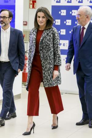 Letizia d'Espagne glamour dans une combinaison 7/8ème rouge vif cachée sous son manteau long léopard.