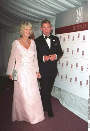 21 juin 2000 : Camilla Parker Bowles aux côtés de son compagnon, le Prince Charles. Elle porte une robe rose satiné pour se rendre à un diner de la fondation des Princes. 