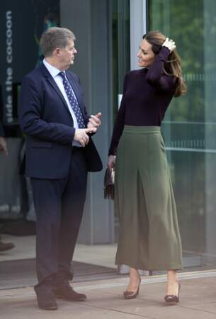 Main dans les cheveux, escarpins prunes Tods assorties à son sac et son top, Kate Middleton savoure sa nouvelle image.