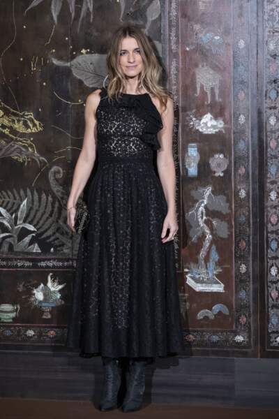 Sonia Sieff porte une longue robe noire en dentelle fleurie pour assister au défilé Chanel Métiers d'Art.
