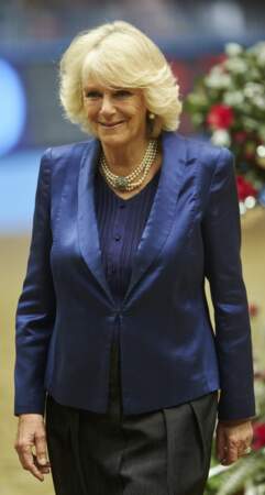 19 décembre 2013 : Lors d'un spectacle équestre en 2013 la duchesse de Cornouailles portait une veste de tailleur mais brillante cette fois-ci, et son collier de perles trois rangs.