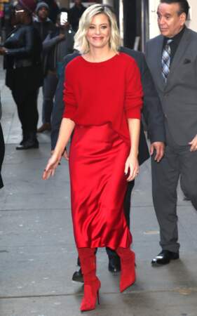 Elizabeth Banks fait sensation dans un total look rouge en jupe satinée, cuissardes et pull oversize dans les rues de New York.