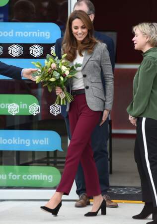 Kate Middleton décontractée-chic en jupe-culotte rouge bordeaux associée à une veste blazer imprimé prince de Galles ultra-tendance.
