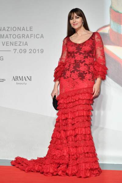 Monica Bellucci incendiaire dans une longue robe rouge en dentelle transparente griffée Dolce & Gabbana.
