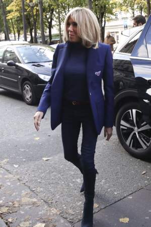 Brigitte Macron décontractée-chic en jean slim assorti à une petite veste blazer bleu nuit.