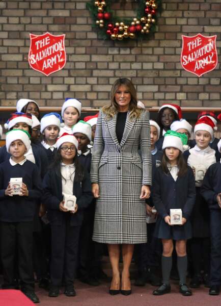 Melania Trump ose la tendance pied-de-poule sur un manteau long de de la marque Alexander McQueen estimé à 2.890 euros pour une distribution de cadeaux au Clapton Center de l’Armée du Salut, dans le nord de Londres, le 4 décembre 2019.