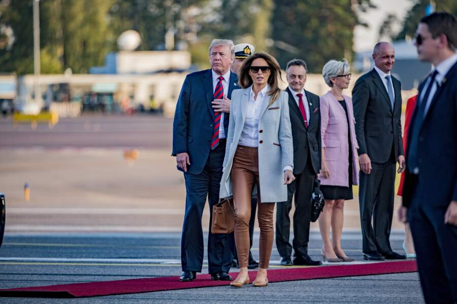 Melania Trump chic en manteau gris et camel de la marque Isoude pour son arrivée à l’aéroport d’Helsinki, le 15 juillet 2018.