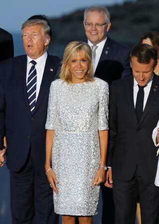 Brigitte Macron élégante dans une robe courte blanche sertie de strass argentés.