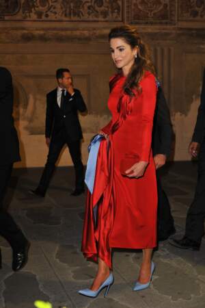 Rania de Jordanie incendiaire dans une longue robe rouge satinée assortie à des escarpins bleu ciel.