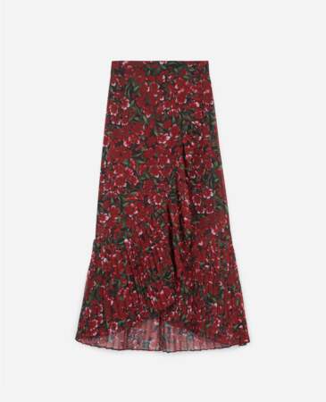 La jupe midi plissée en matière aérienne et à l’imprimé fleuri aux roses rouge passion, The Kooples, 198€.