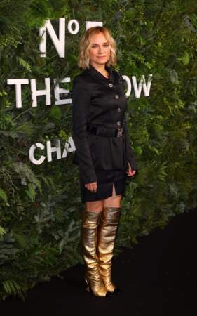 Diane Kruger complète son total look noir avec une paire de bottes plissées dorées signée Chanel.