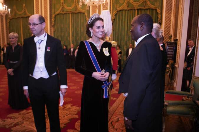 Comme un hommage à Elisabeth II, Kate Middleton portait un médaillon jaune à l'effigie de la reine.