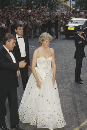 Diana resplendit dans une robe blanche et dorée, signée David et Elizabeth Emanuel, lors de la première de "Tuer n'est pas jouer" à Londres en juin 1987. 