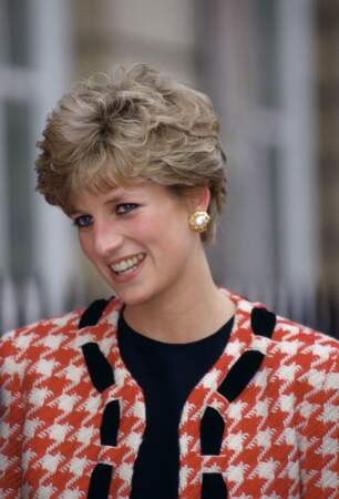 La princesse Diana, avec une veste à imprimé pied de poule rouge et crème signée Moschino, lors de la visite d'un hôpital à Londres en 1992.