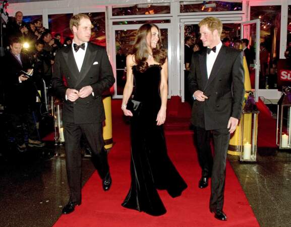 Kate Middleton, accompagnée du prince William et du prince Harry,  dans une robe bustier noire Alexander McQueen, lors de la cérémonie "The Sun Military Awards" à Londres, le 19 décembre 2011.