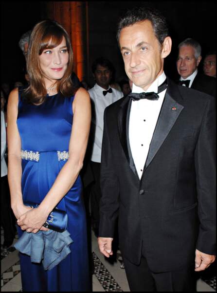 En Septembre 2008, Carla Bruni accompagne son mari lors d'un séjour à New York. La Première dame resplendit en robe bleue, au côté de son homme élégant en smoking noir.