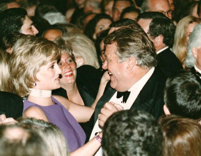 La princesse Diana, dansant avec l'homme d'affaire Michael Wilkie lors d'une soirée caritative à Chicago en 1996. Elle porte un collier tour de cou composé de onze rangées de perles. 