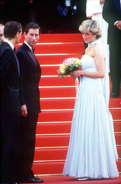 Charles et Diana sur les marches du Festival de Cannes 1987. La princesse est vêtue d'une robe Catherine Walker, accessoirisée de boucles d'oreilles en aigue-marine et diamants. 