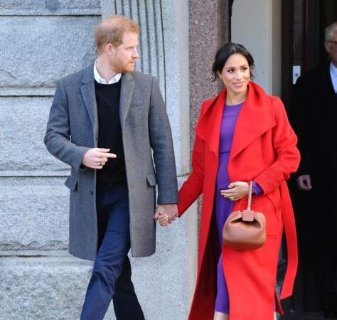 La duchesse Meghan Markle fait sensation à Birkenhead le 14 janvier 2019 en mixant cette robe violette à un manteau rouge.