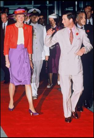 La princesse Lady Di est aux côtés du prince Charles lors d'une visite à Hong kong. Mélanger le violet et le rouge est un choix osé que Meghan Markle n'a pas hésité à reproduire.