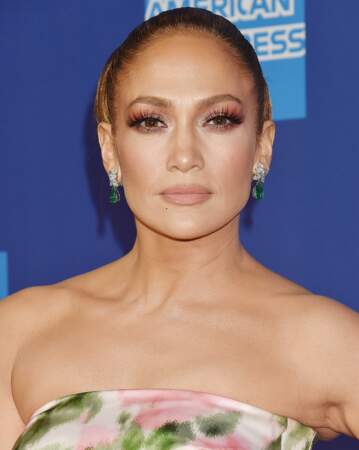 Jennifer Lopez a opté pour un joli bun et un joli fard rosé et orangé sur les yeux.
