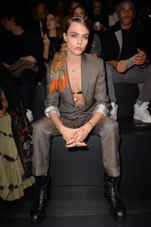 Cara Delevingne avait opté pour un costume gris et un foulard dans les cheveux pour le défilé Homme de Dior à Paris.