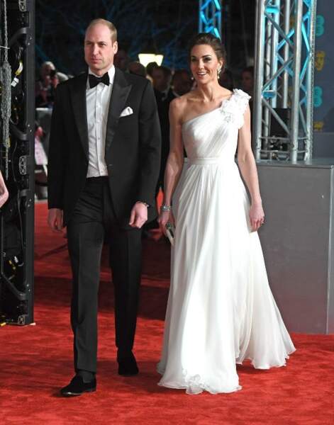 Le prince William et Kate Middleton à la 72e cérémonie des BAFTA Awards le 10 février 2019 à Londres. Pour l'occasion, la duchesse de Cambridge porte une sublime robe blanche plissée signée Alexander McQueen, laissant l'une de ses épaules nues.