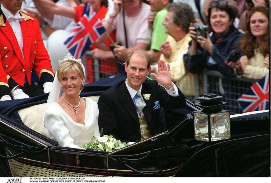 19 Juin 1999 : Sophie Rhys-Jones devient la comtesse de Wessex. Elle porte un long voile retenu par un diadème offert par la Reine d’Angleterre. Ses boucles d’oreille et son collier en perles sont un présent du prince Edward.