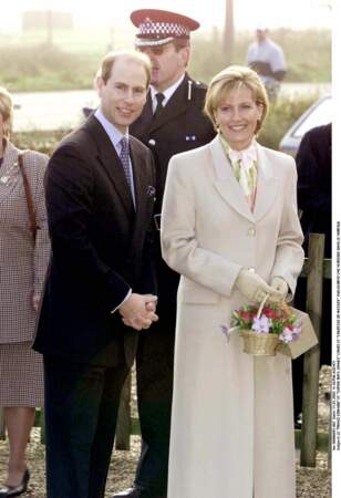 2002 : Sophie de Wessex et son époux, le prince Edward lors de l'inauguration d'une nurserie dans le Norfolk. Elle porte un long manteau beige en coupe droite ainsi qu'un petit sac panier. Un style élégant et chic.