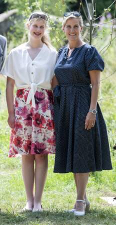 23 juillet 2019 : Sophie de Wessex est en compagnie de sa fille, Louise, 16 ans. Elles visitent le zoo " Wild Place Project " à Bristol. Elle porte une petite robe à pois bleu marine ceinturée au niveau de la taille. Pour une fois, elle ne porte pas de chapeau, remplacé par une paire de lunettes de soleil. 