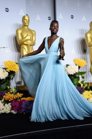 Lupita Nyong'o porte une robe décolletée Prada lorsqu'elle remporte l'Oscar de la meilleur actrice dans un second rôle lors de la 86e cérémonie en 2014 .