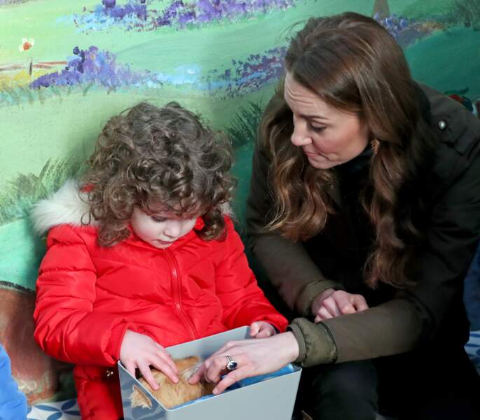Kate Middleton en pleine intéraction avec une fillette fascinée par un cochon d'inde : la duchesse croit beaucoup à la force des liens sociaux dans l'épanouissement d'un enfant. 
