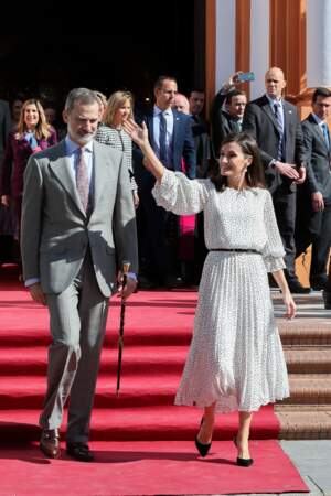 Le roi Felipe VI d'Espagne et la reine Letizia saluent la foule lors de la visite d'une église à Huelva le 14 février 2020. Cette robe blanche à pois est un modèle que la reine apprécie particulièrement. Elle portait une robe similaire lors d'une apparition à Séville début février 2020