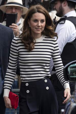 Kate Middleton adore la marinière : en 2019 elle porte une marinière à rayures bleues et blanches et un pantalon marine à gros boutons blancs. 