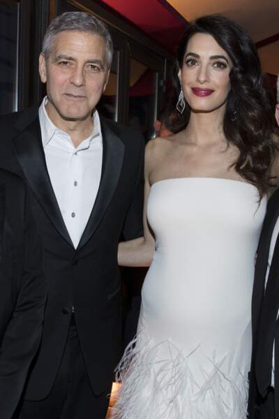 Amal et George Clooney sont présents à la cérémonie des Césars 2017 pour récompenser l'acteur avec un prix honorant sa carrière. Amal Clooney porte une robe qui allonge sa taille par l'effet des plumes dégradées sur le bas de la robe alors qu'elle est enceinte de ses jumeaux.  