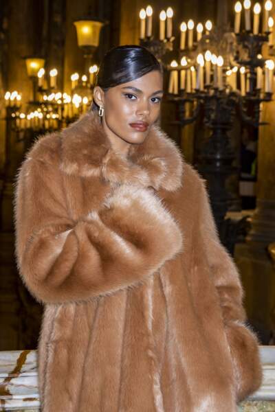Tina Kunakey portait un manteau de fausse-fourrure oversize au défilé Stella McCartney