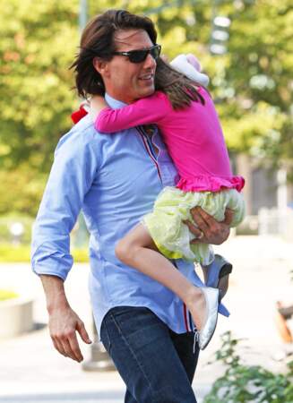 Suri Cruise dans les bras de son père, en août 2011, dans un look très coloré.